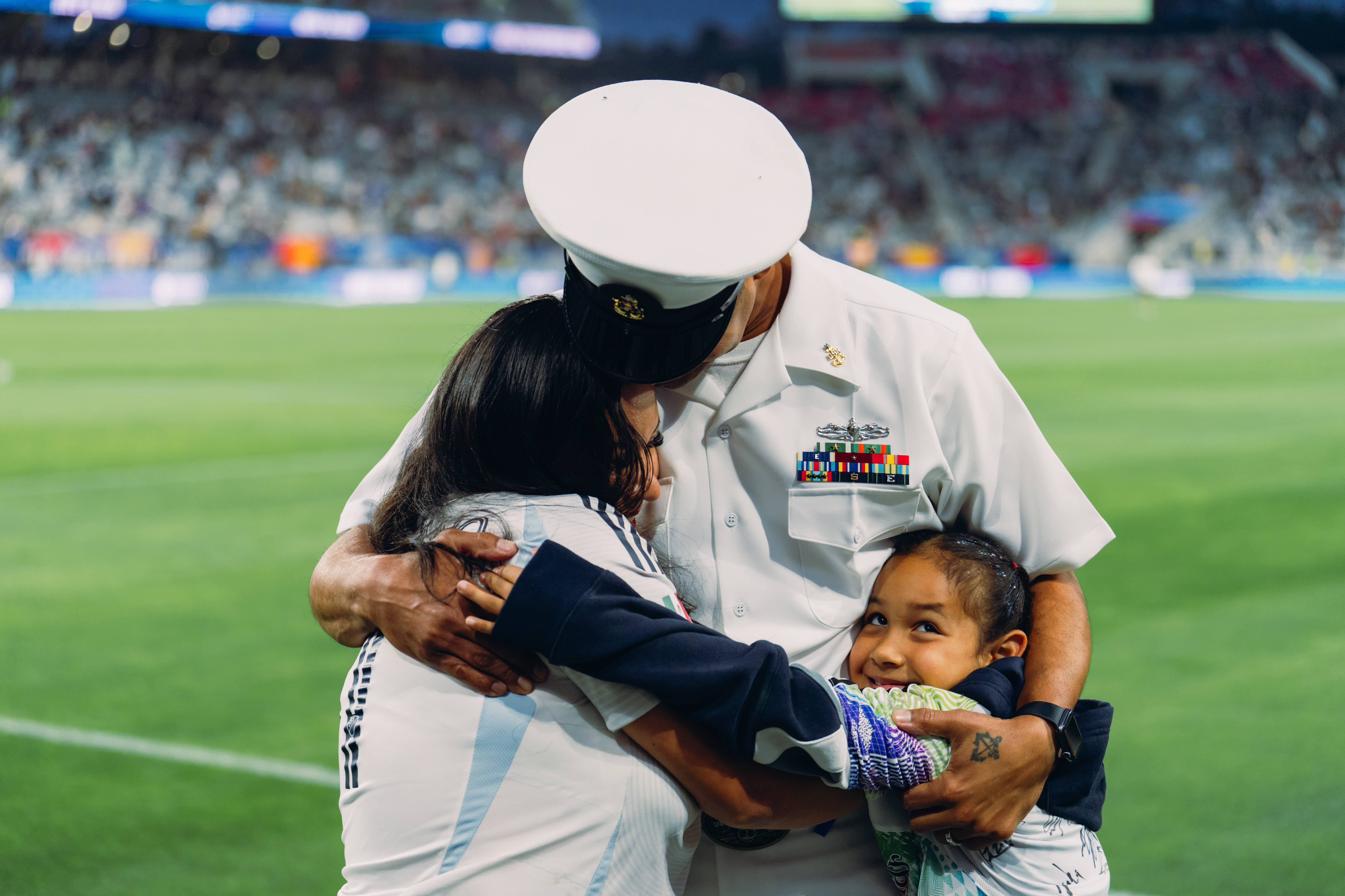Husband, wife, and Daughter hugging 