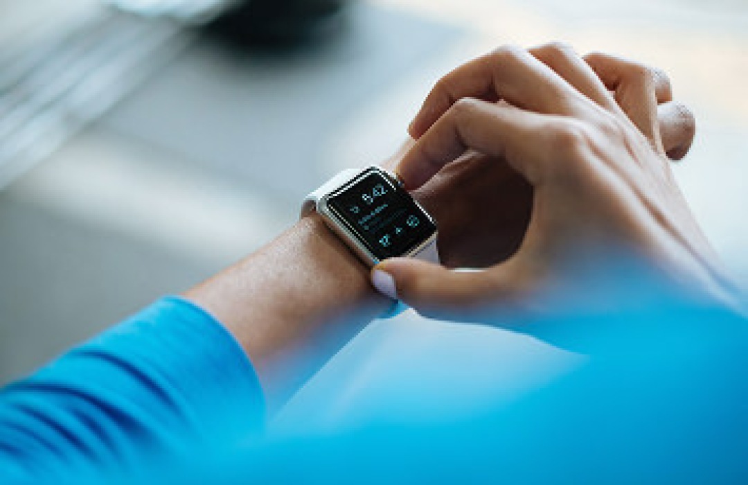 Person interacting with a smartwatch on their wrist.