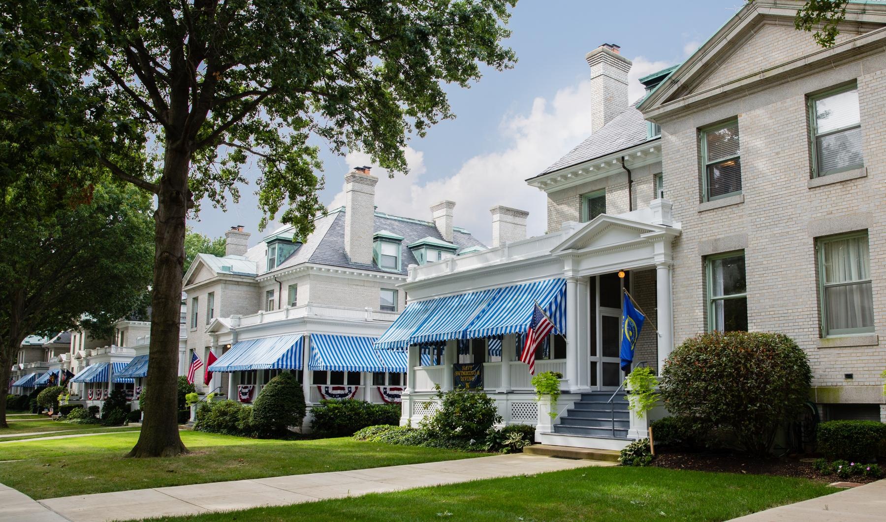a building with a blue awning and a lawn in front of it