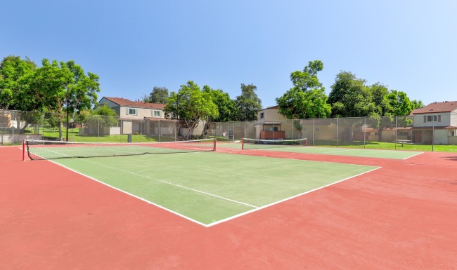 tennis courts in a community surrounded by houses
