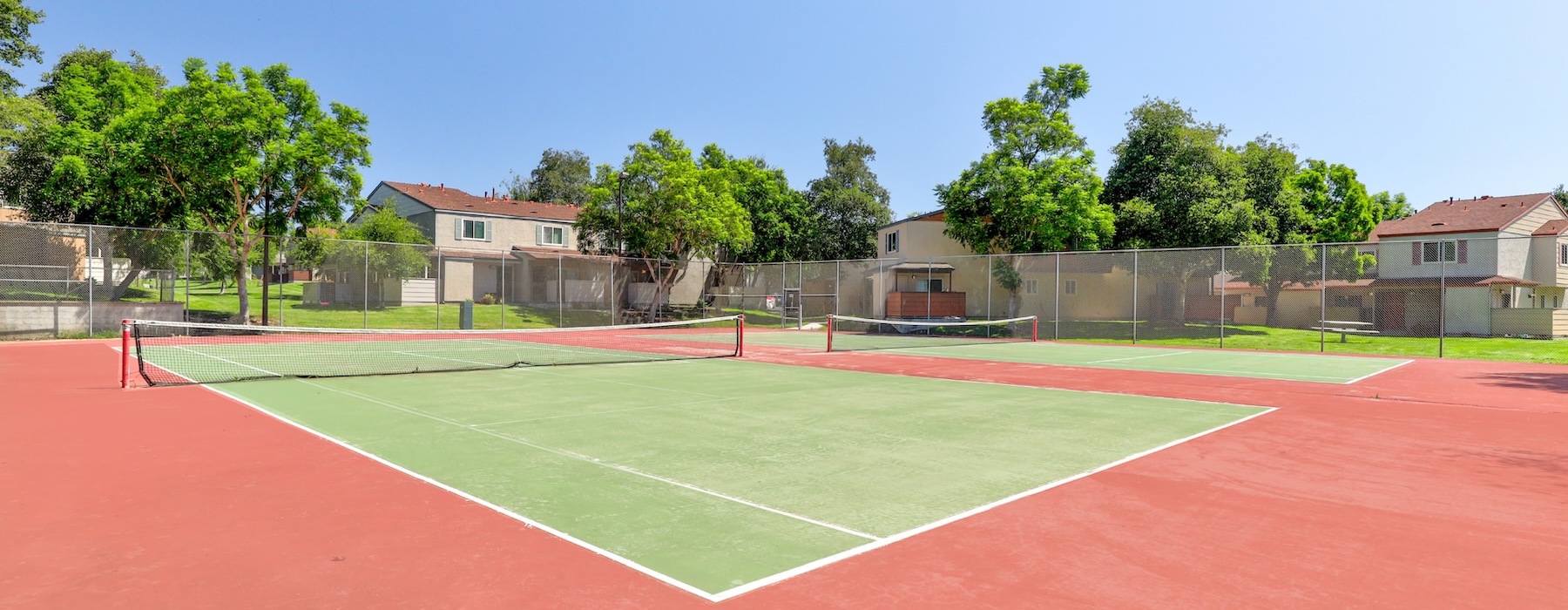 tennis courts in a community surrounded by houses