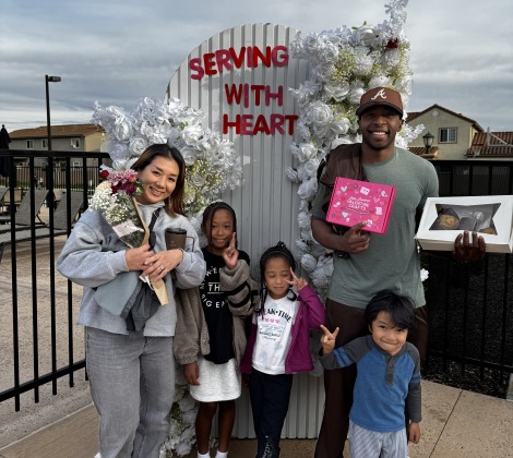 Family Standing in Front of Valentines Day Sign 