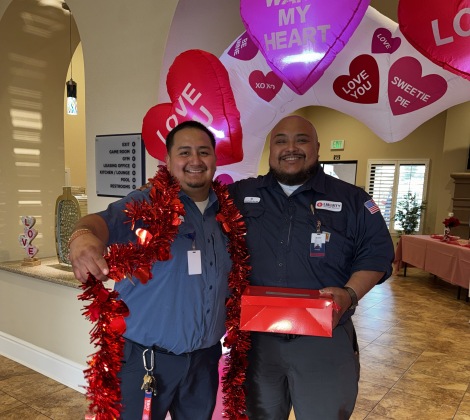 Liberty Team Members stand in front of heart balloon arch 