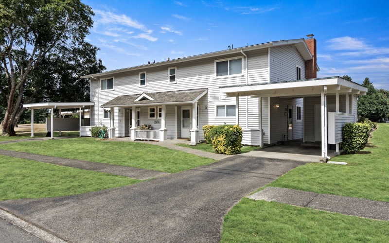 a house with a driveway and a lawn in front of it