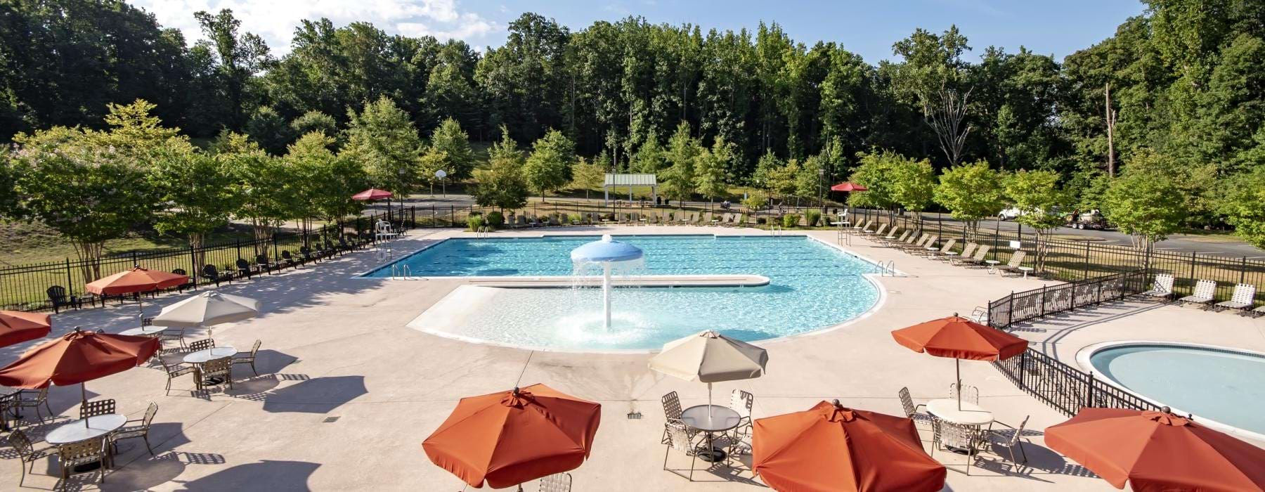 a pool with umbrellas and chairs next to it