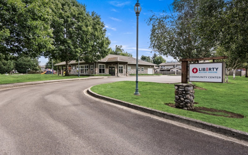 a road leading to a building with a sign