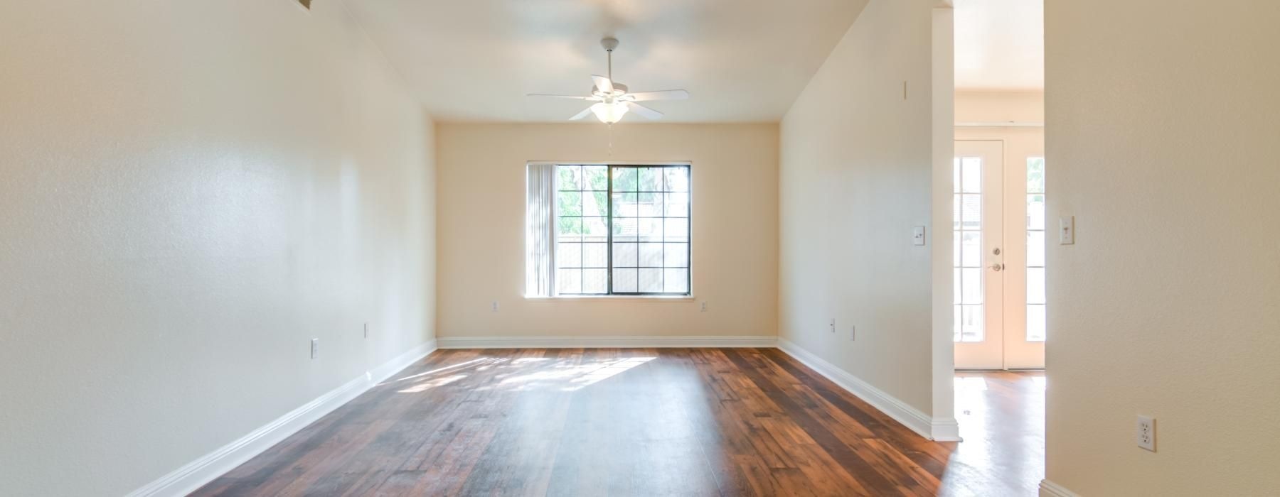 a room with a wood floor and a ceiling fan