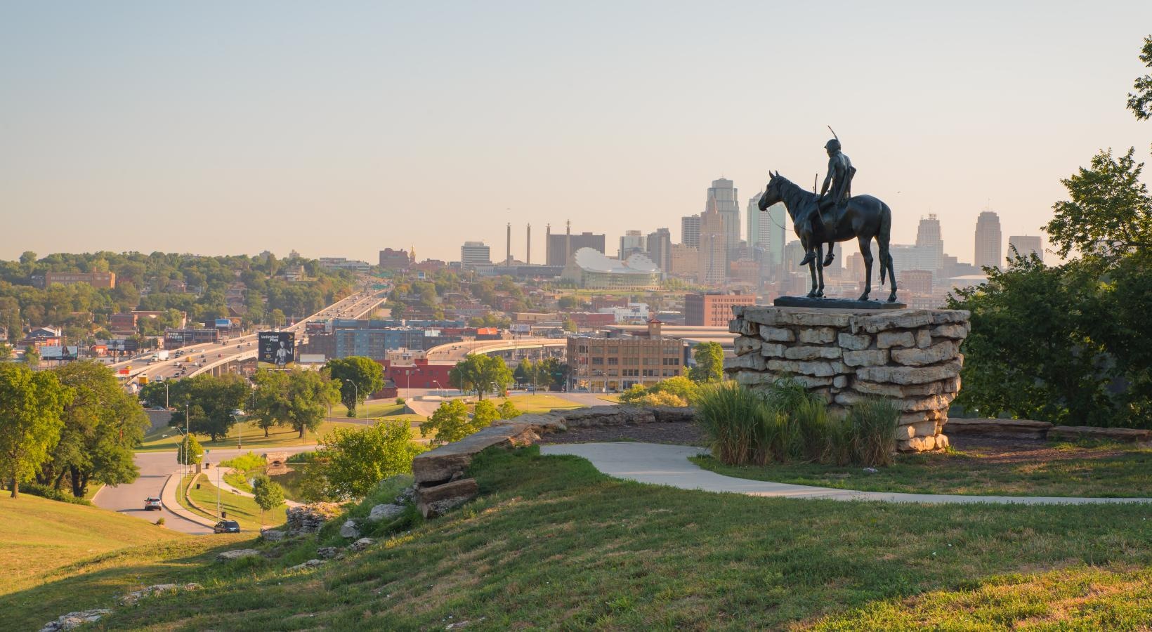 a statue of a person riding a horse on a hill with overlooking the city