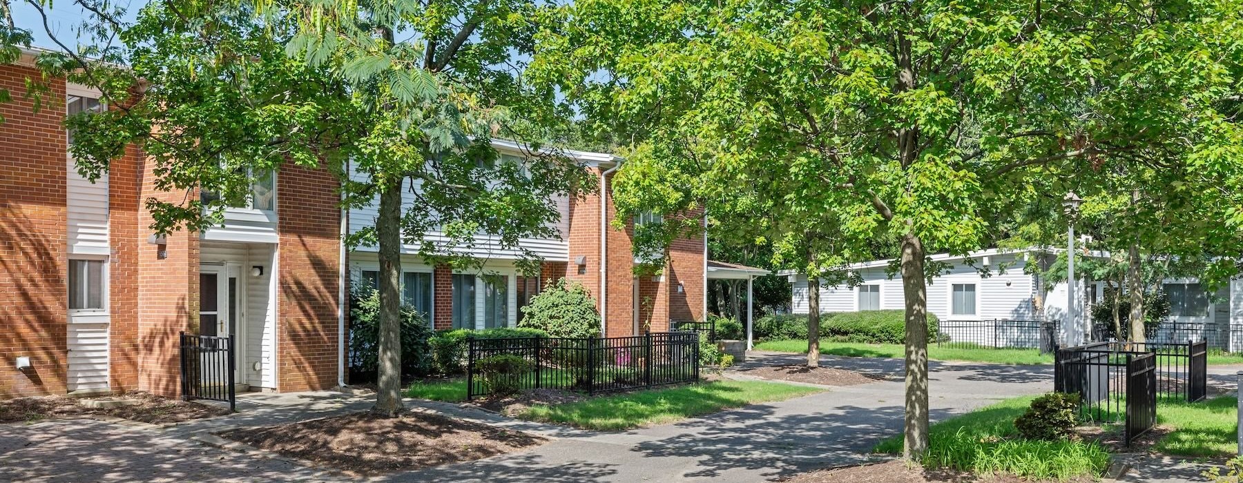 a brick building next to a street and sidewalk with trees