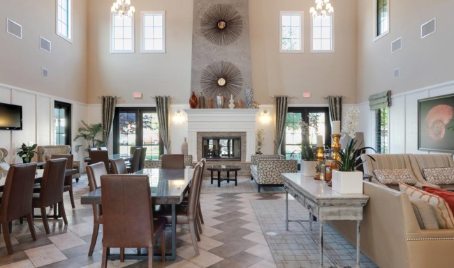a large club room with a large chandelier and a couch