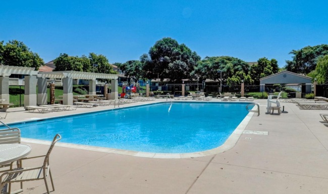 a swimming pool with chairs around it