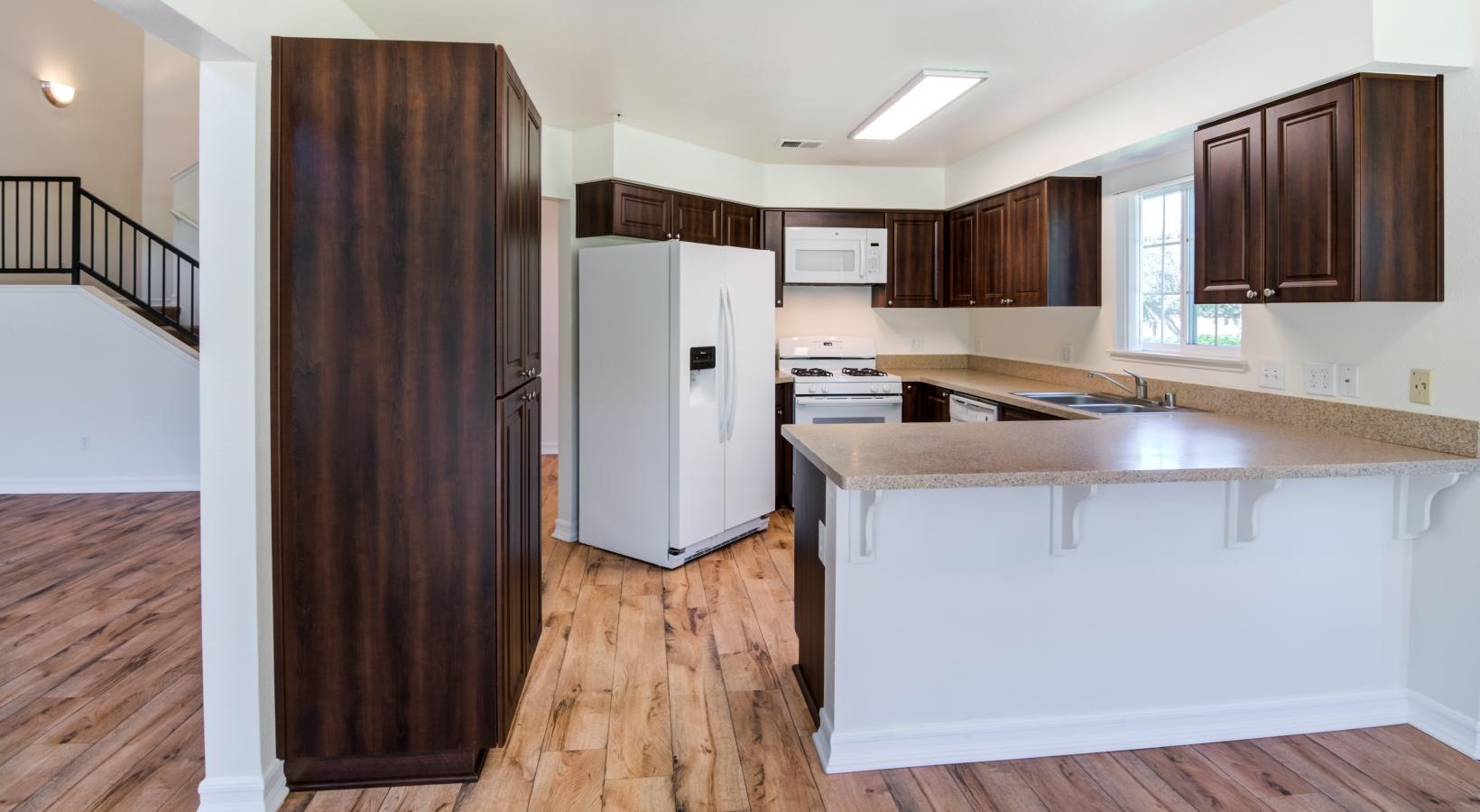 well lit kitchen with wooden cabinets