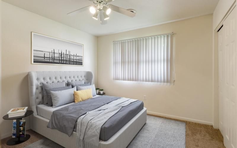 a bedroom with a bed and a ceiling fan