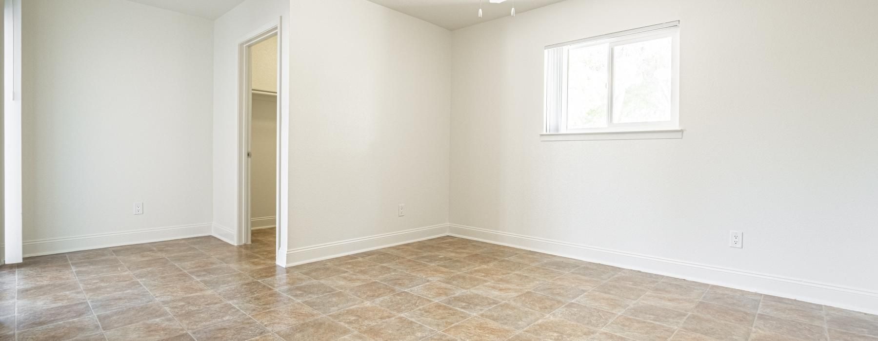 a room with a ceiling fan and a tile floor