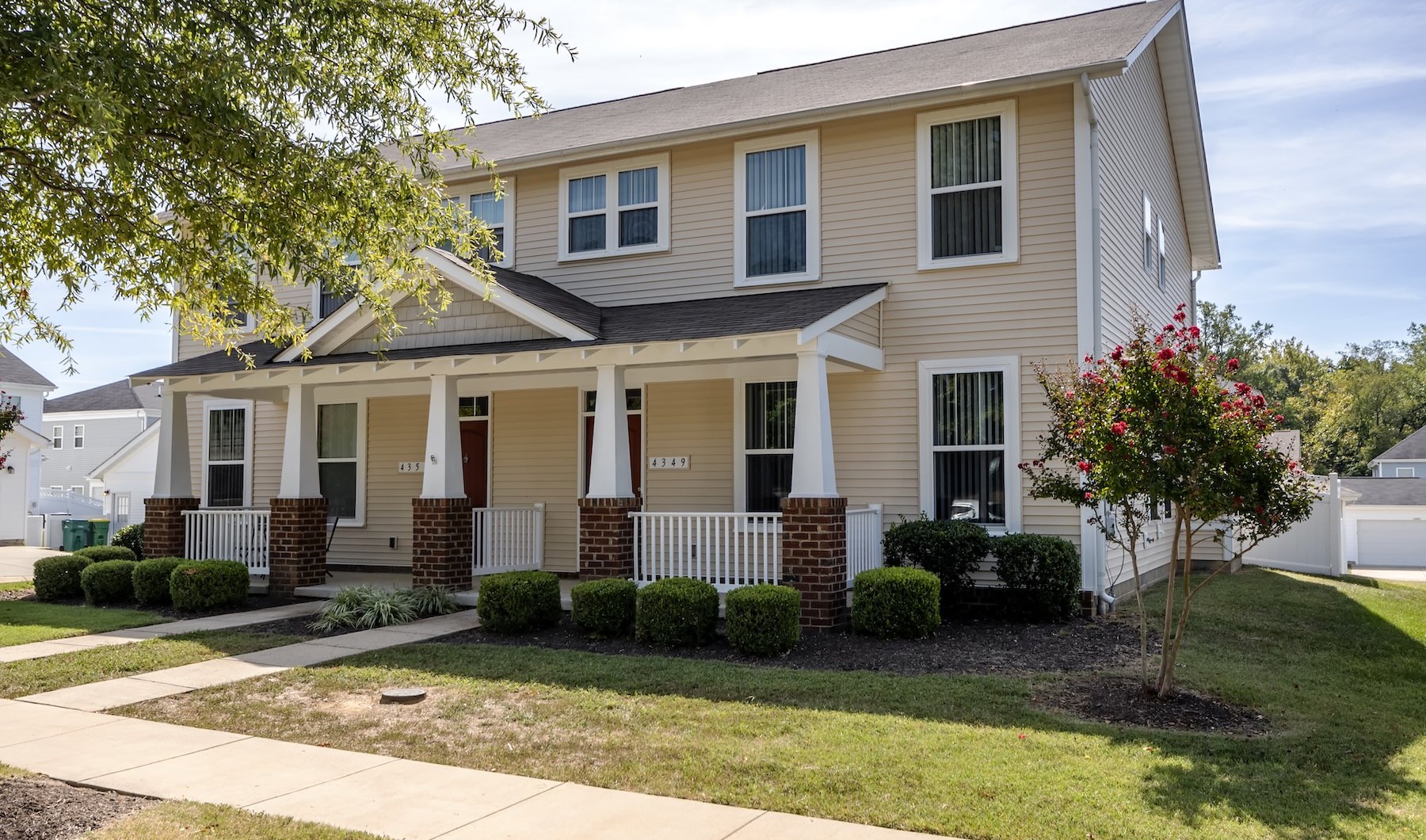 townhomes with trees and a walkway in front of it