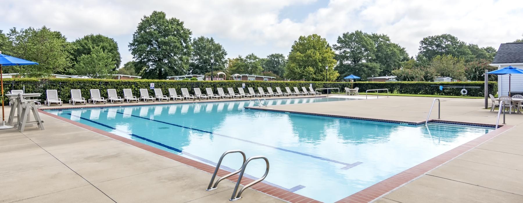 a swimming pool with trees in the background