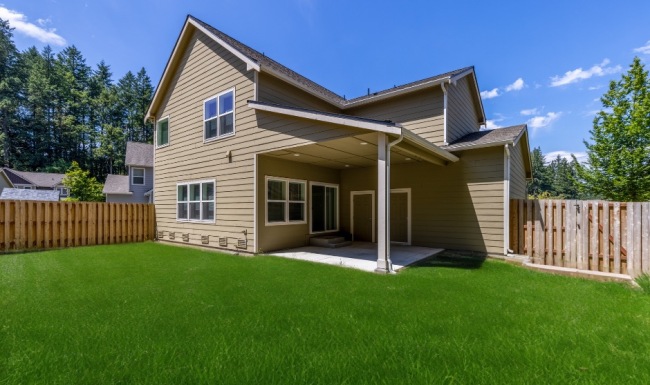 a fenced in backyard with a home