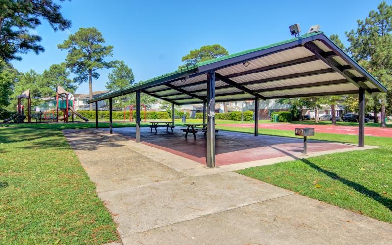 a playground with a slide and a covered pavilion