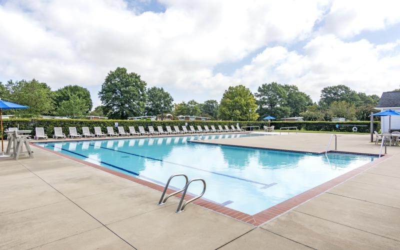 a swimming pool with trees in the background