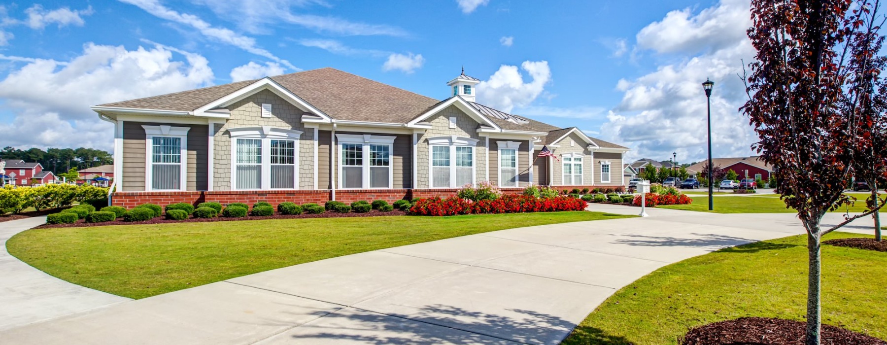 a large club house with landscaping and a driveway