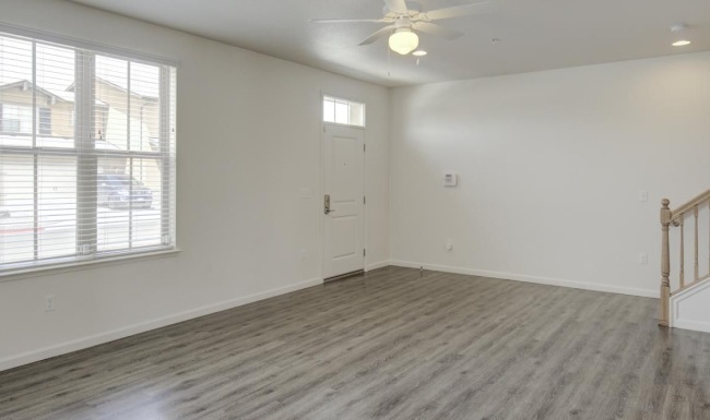 a room with a wood floor and a ceiling fan
