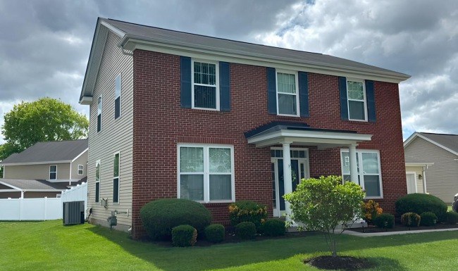 a brick house with green grass 