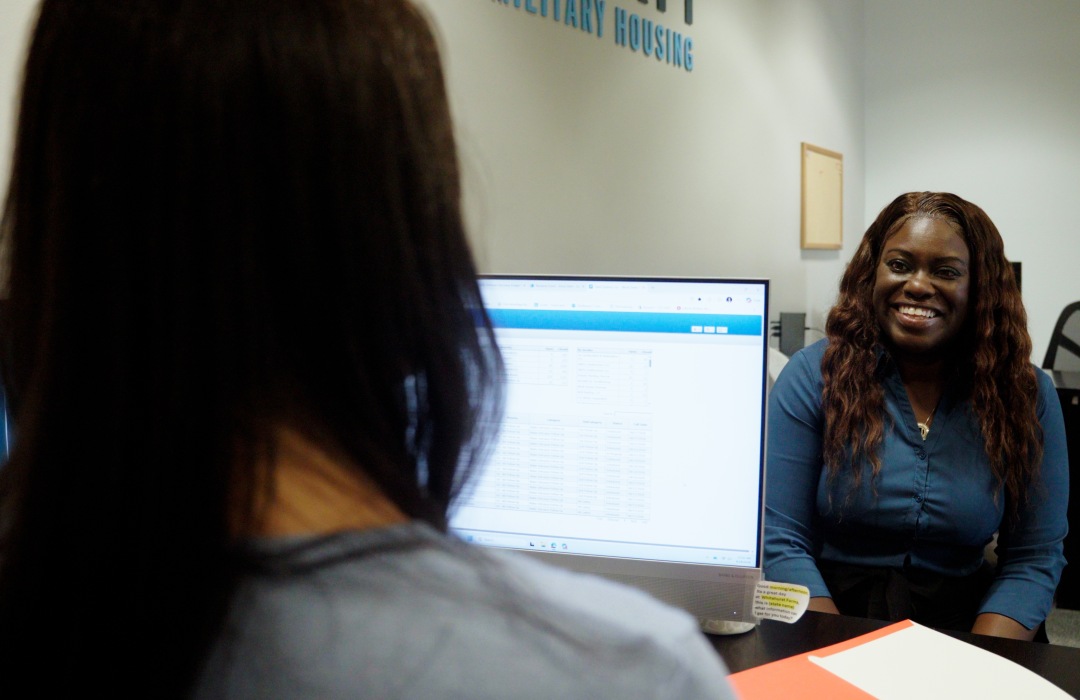 Liberty Team Member at desk helping resident or prospect find a home.