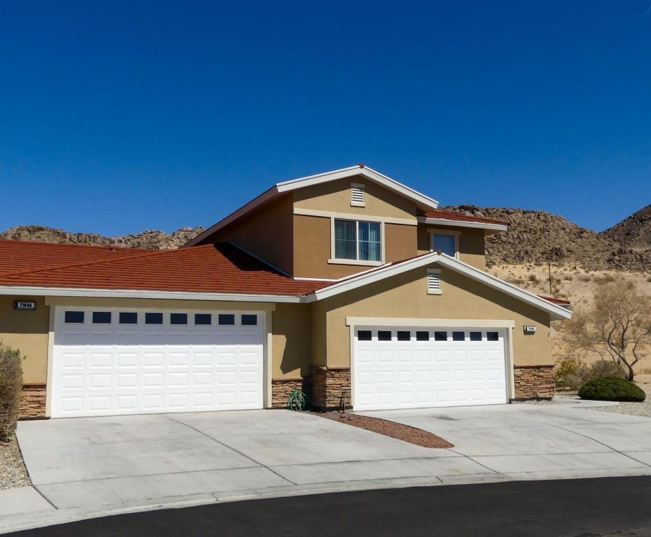 a building with a garage and a hill in the background