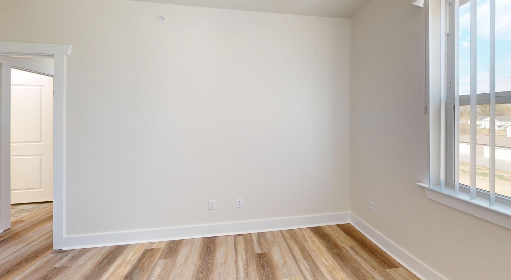 a room with a wood floor and a large window