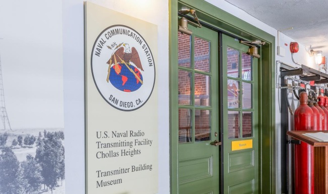 a room with a sign and a door with a painting on the wall