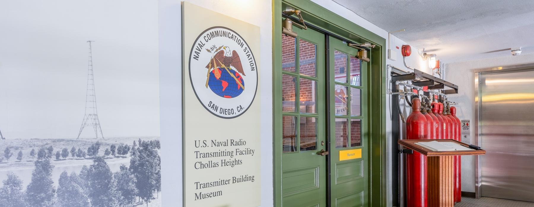 a room with a sign and a door with a painting on the wall