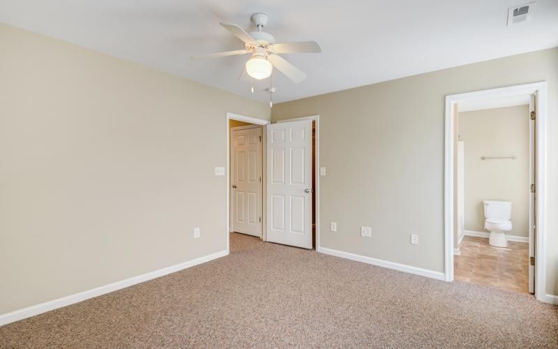 a room with carpet and a ceiling fan