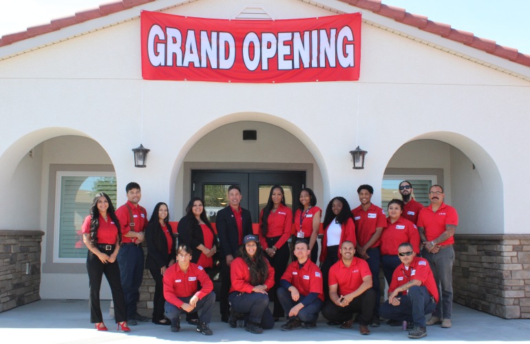 Team members under grand opening sign 