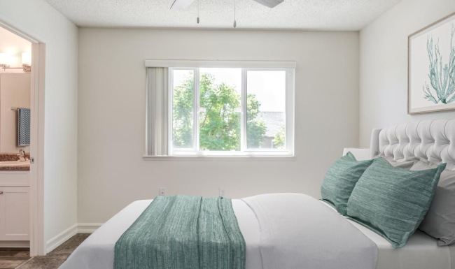 a bedroom with a bed and a fan