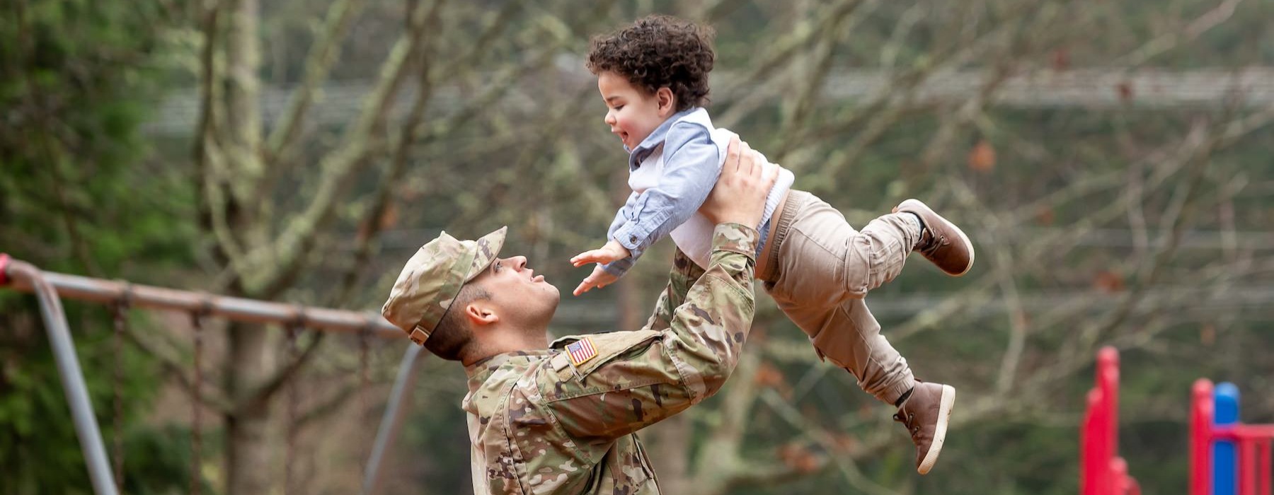 a man holding a child at the park
