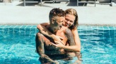 a man and woman hugging in a pool