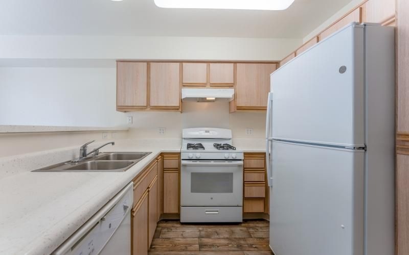 a kitchen with white white appliances