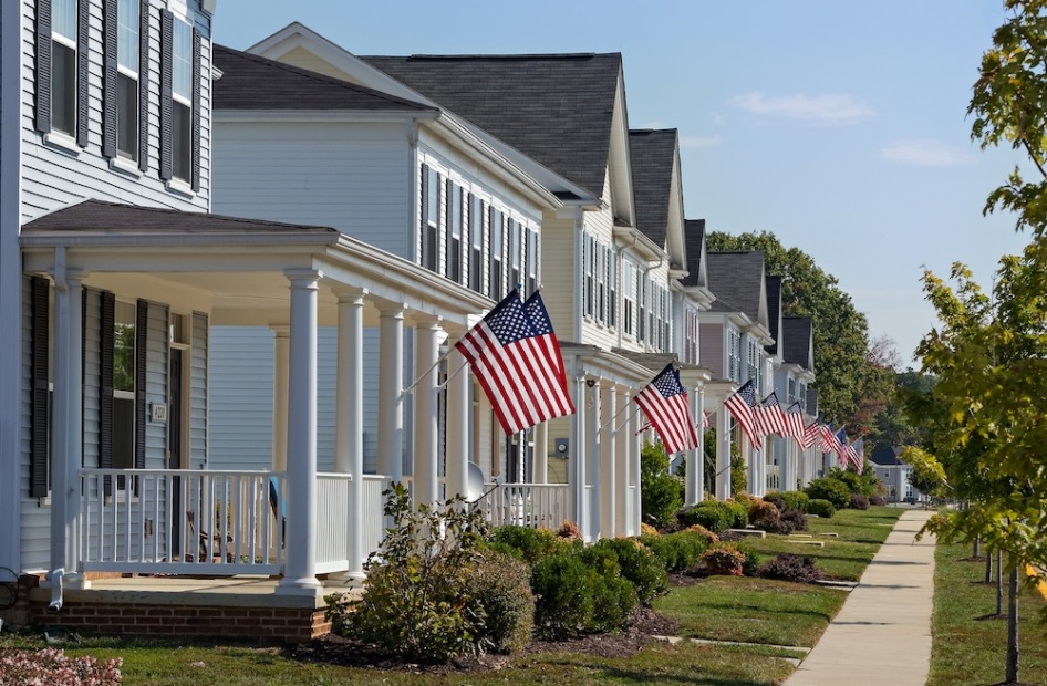 Row of white homes with American Flags