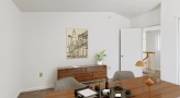 office with desk, chair, and table. Notebook, desk accessories, and lamp on desk