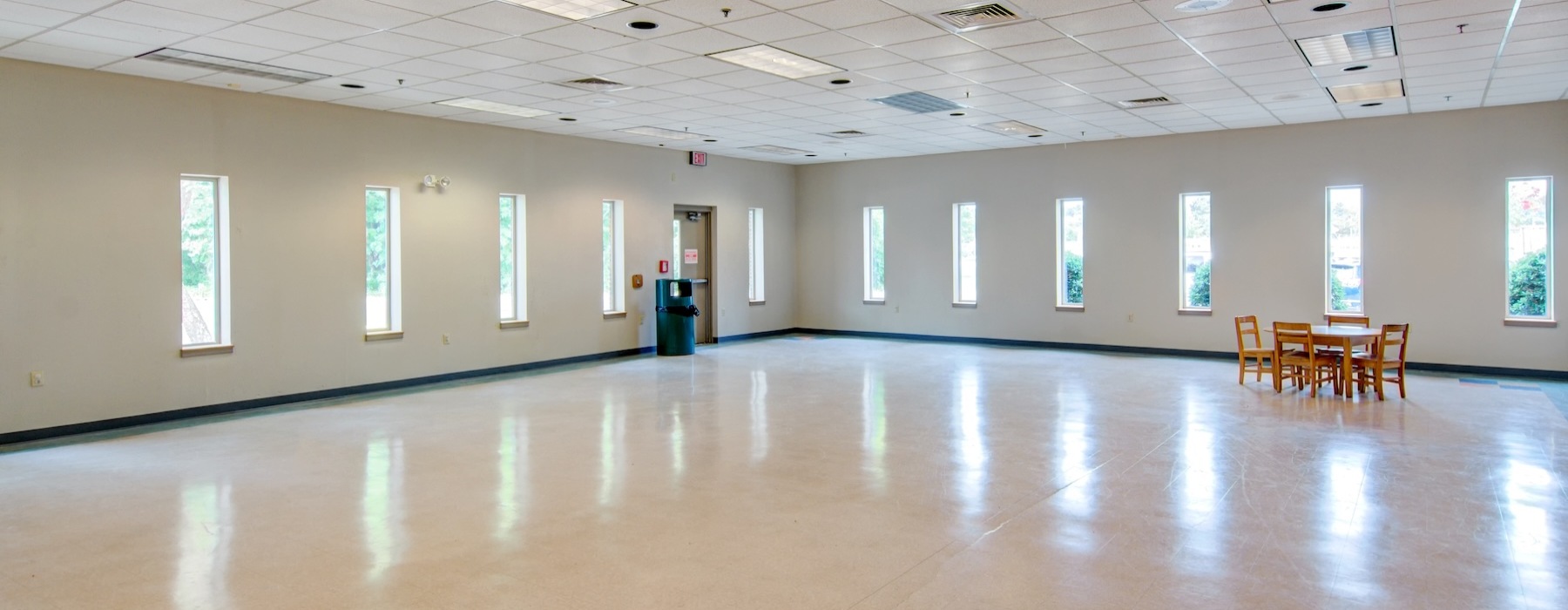a spacious well - lit room with a table