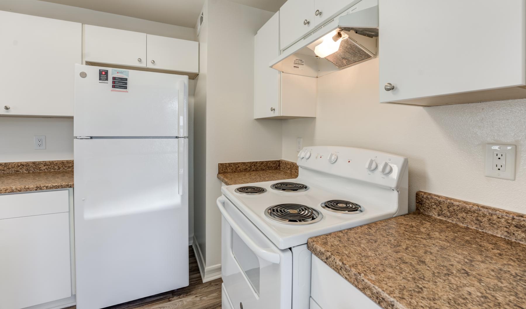 a kitchen with white cabinets and appliances