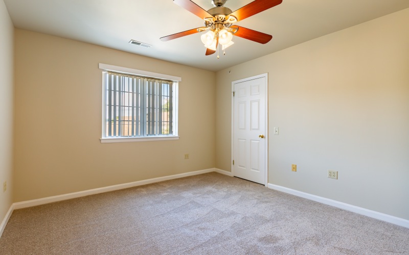 bedroom with carpet ceiling fan and windows
