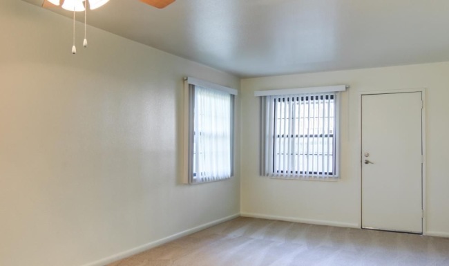 a room with a ceiling fan and a wood floor