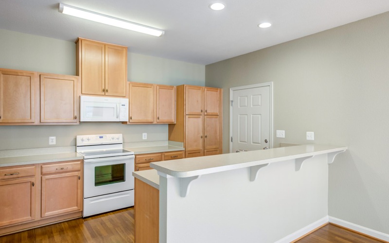 a kitchen with wooden cabinets and white appliances