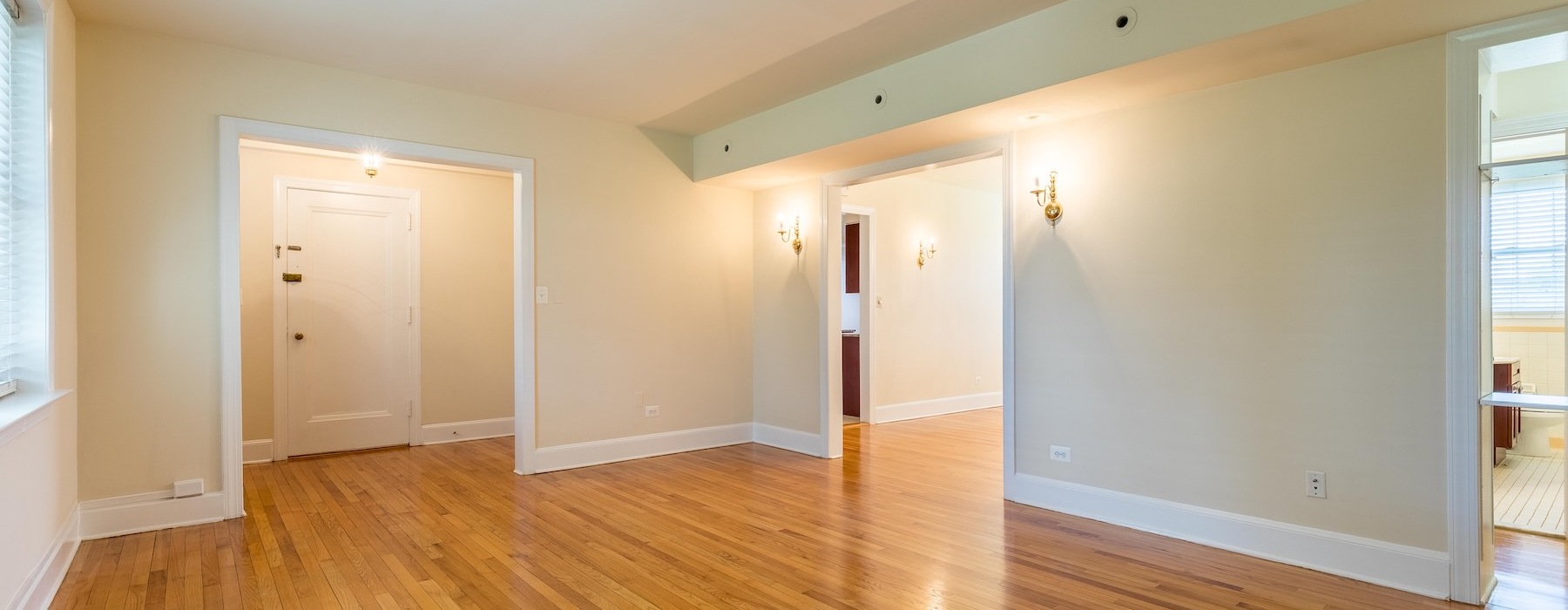 a room with wood-style flooring and cream color walls