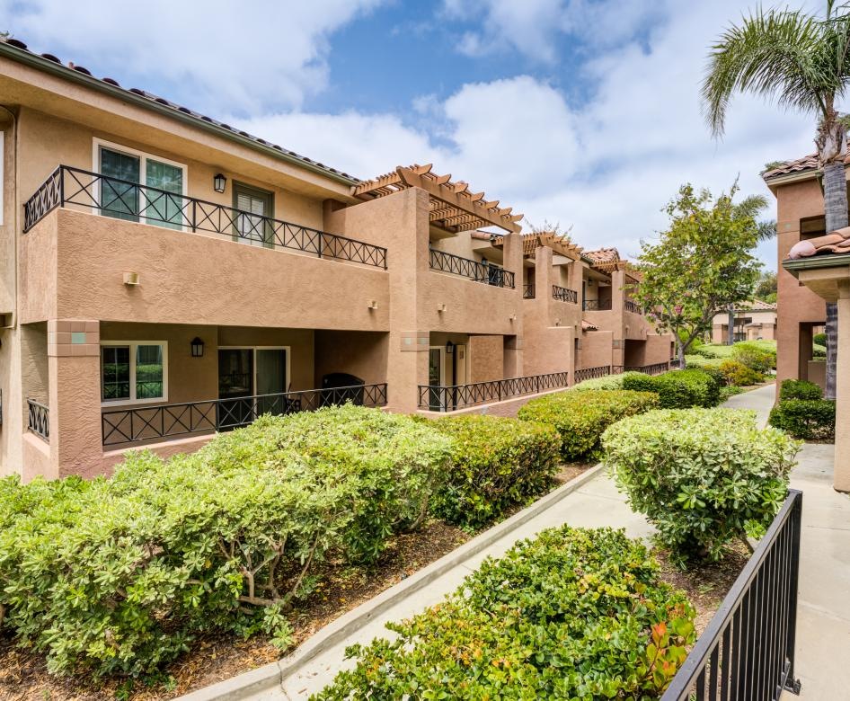 a building with a walkway and bushes