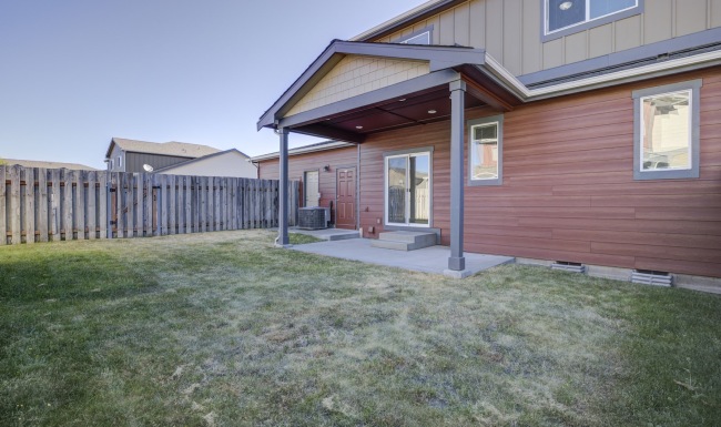 backyard to a red and tan house