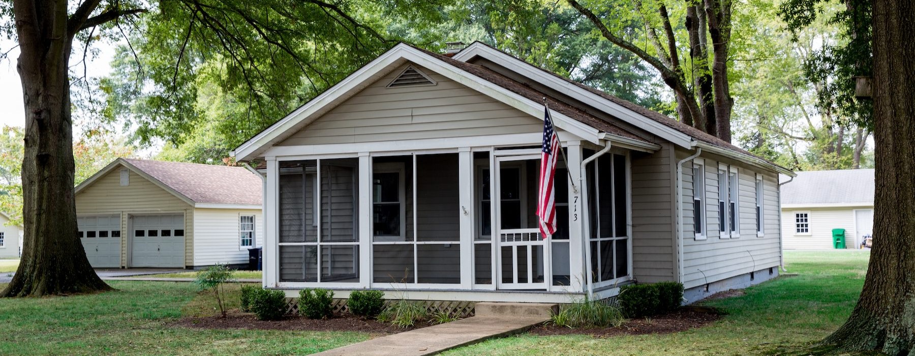 a home amongst trees with an American flag