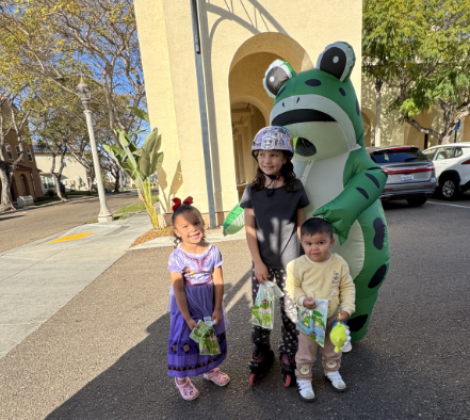 Frog costume posing with kids at Liberty Event 
