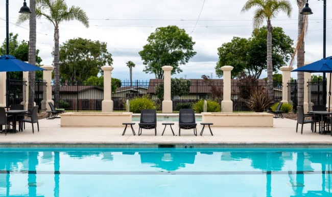 a pool with chairs and umbrellas by it